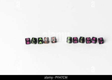 Text `Black Friday` composed of small black blocks with colored letters on white background. Stock Photo